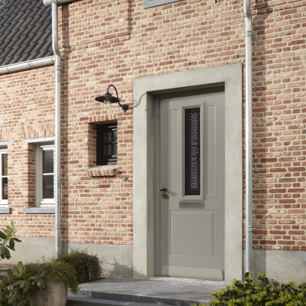 Stallamp Rhone met zwarte gietijzeren wandarm, zwarte aluminium kap en heldere glazen stolp, E27.