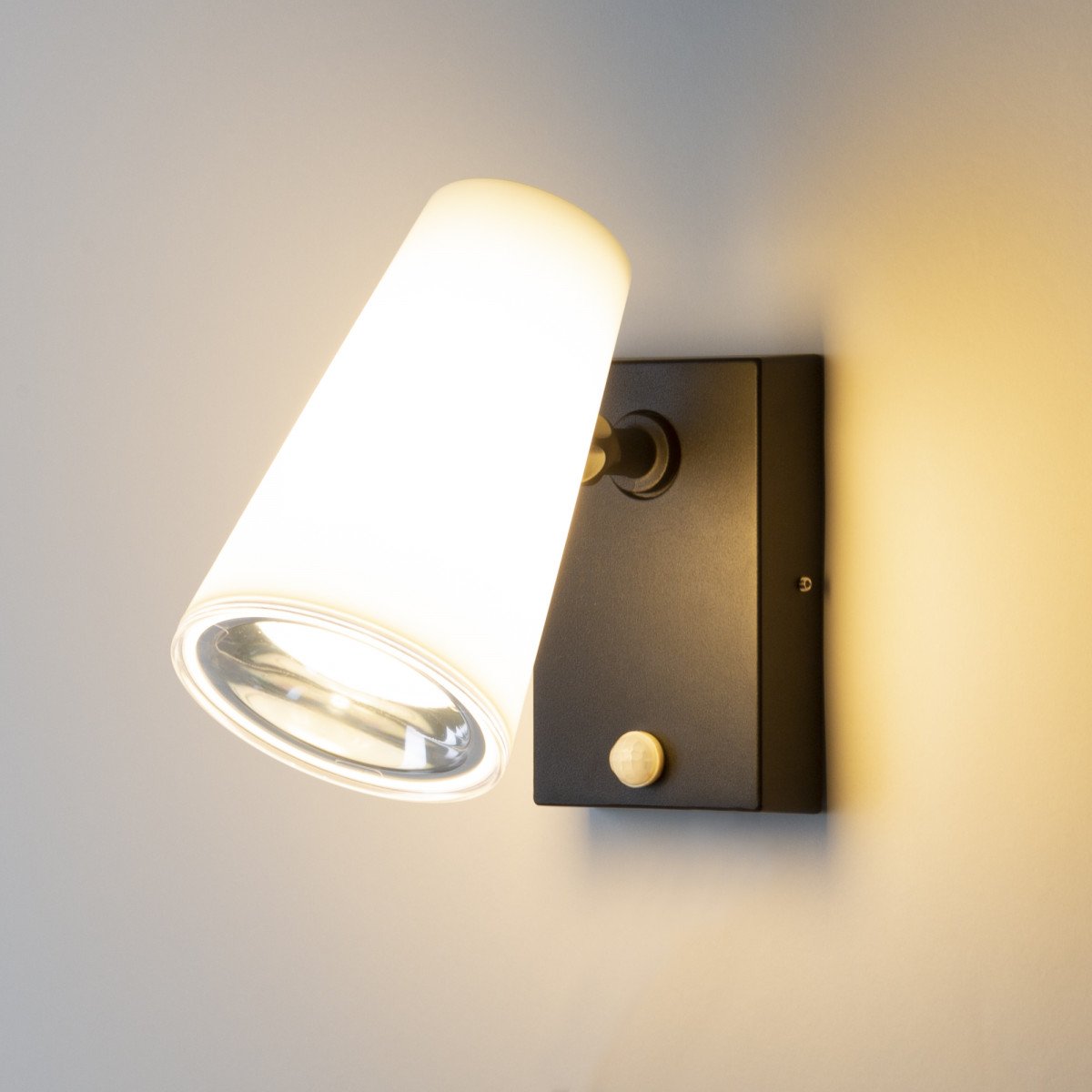 Verstelbare wandspot zwart/wit met sensor, buitenlamp met E27 fitting en gerichte bewegingsgestuurde verlichting.
