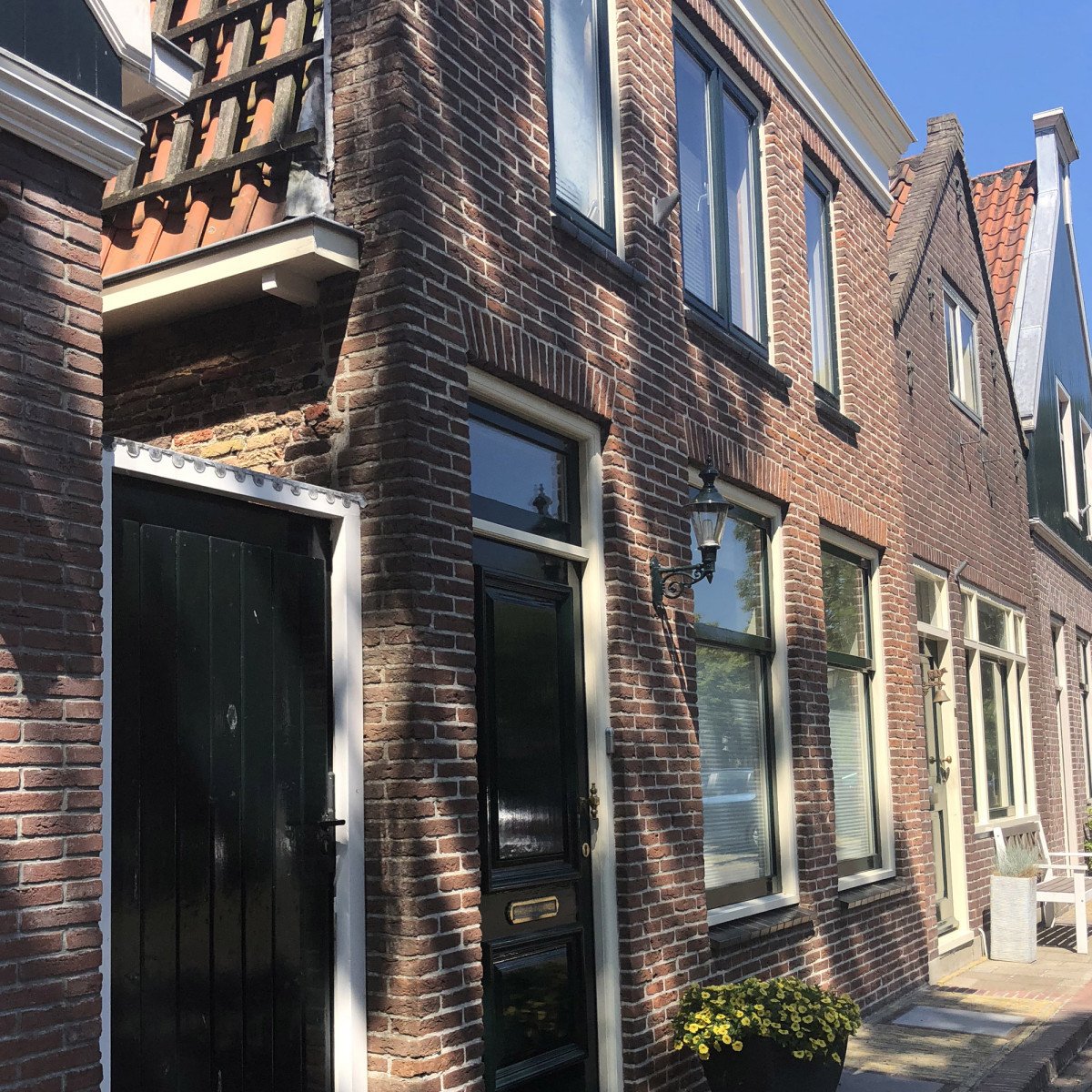 Buitenlamp Edam M met koperen deksel, groene wandarm en helder kunststof glas