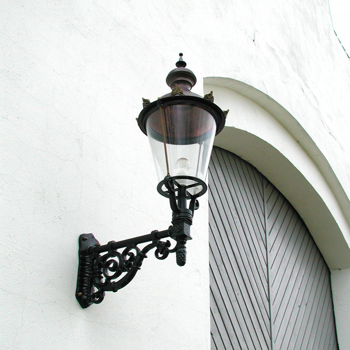 Buitenlamp Amsterdam met koperen deksel en sierlijke zwarte wandarm