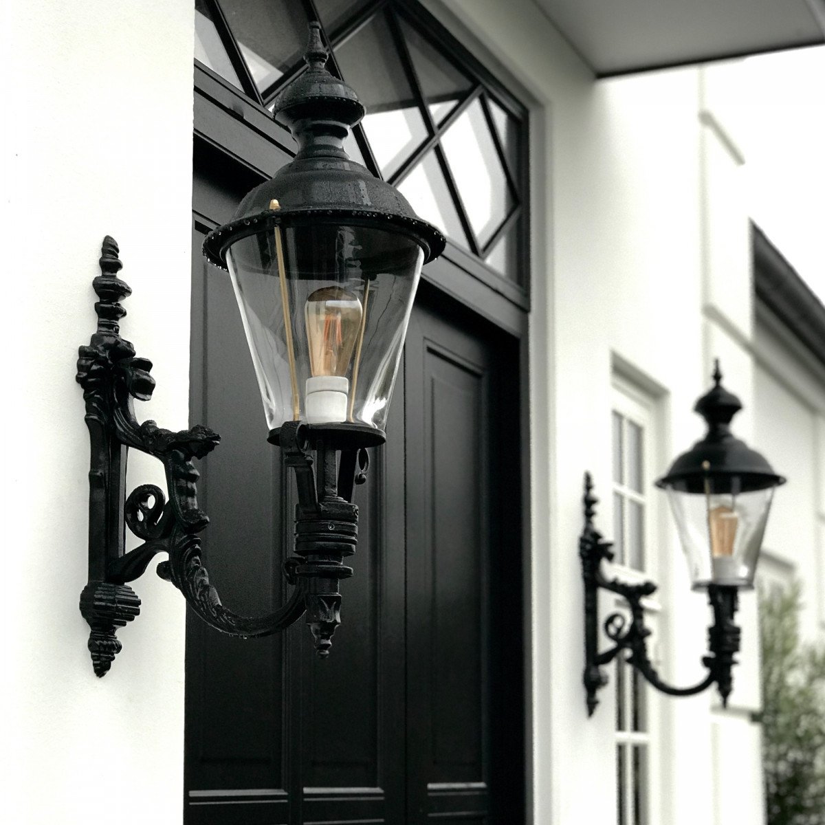 Muurlamp Odense L met koperen deksel, zwarte wandarm en helder kunststof glas