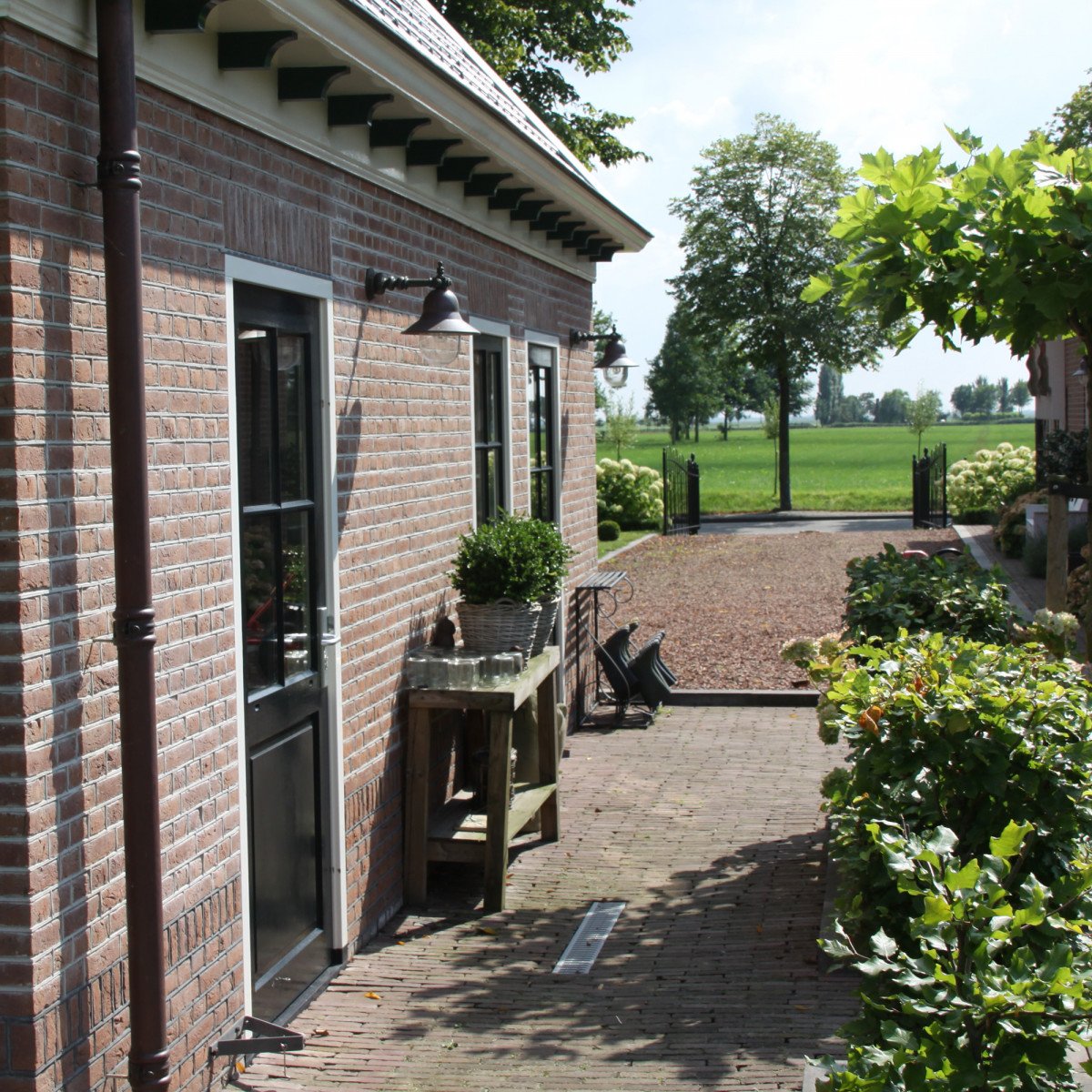 Buitenlamp Bretagne wandmodel met bronzen arm, koperen kap en heldere kunststof stolp – klassieke KS buitenverlichting