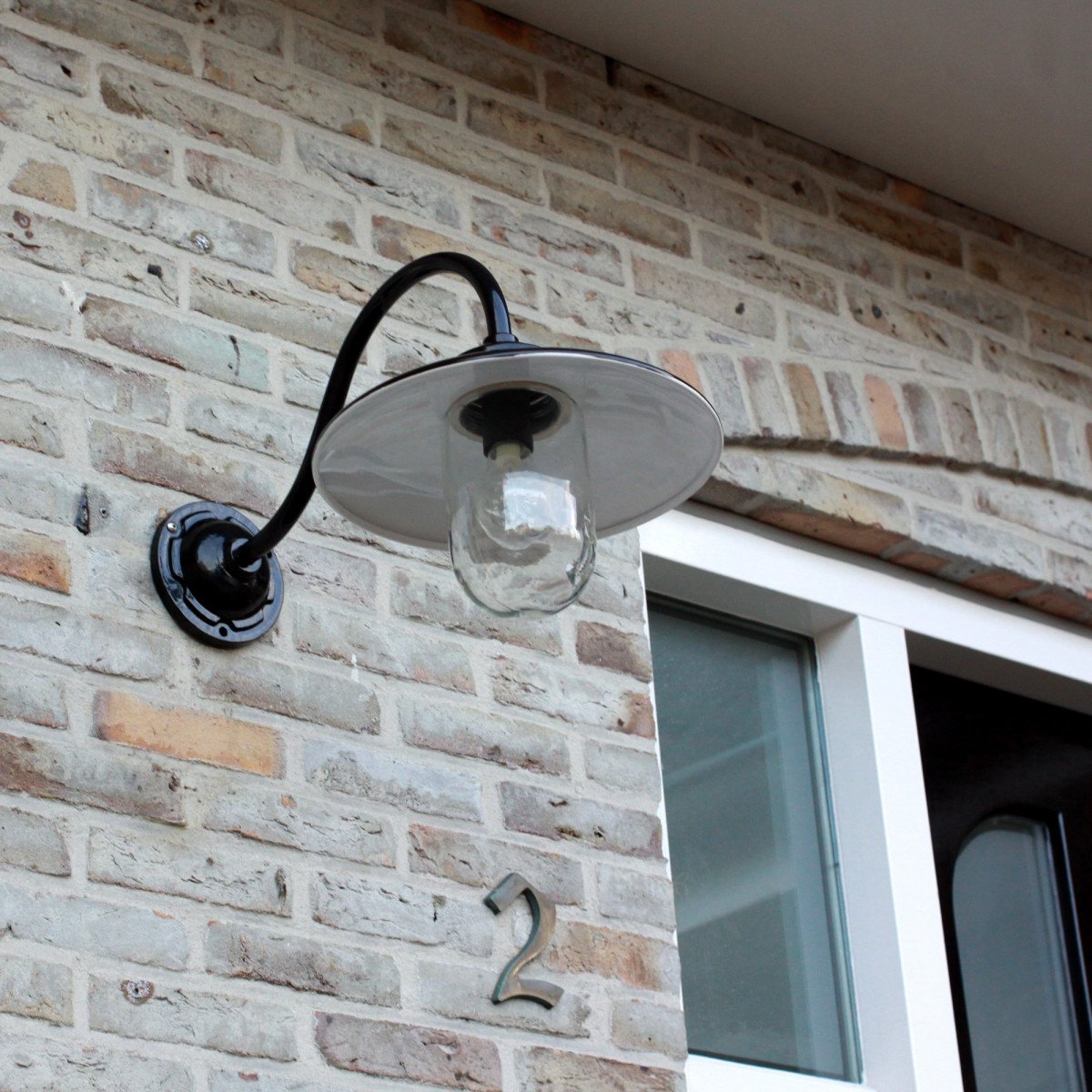 Muurlamp Solingen met zwanenhals in hoogglans zwart en witte binnenzijde, voorzien van heldere glazen stolp.