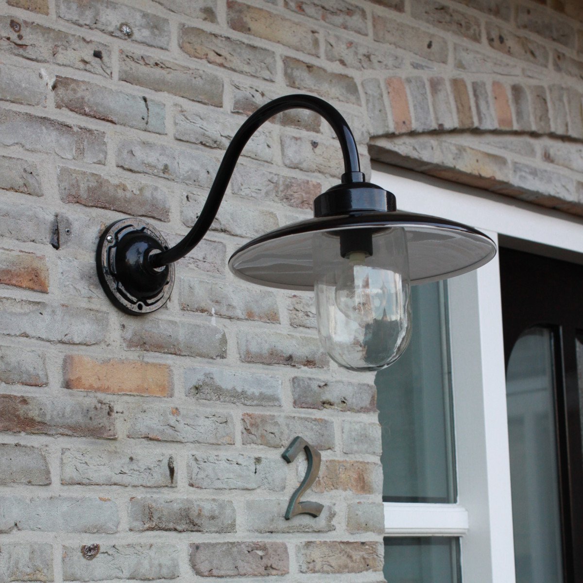 Muurlamp Solingen met zwanenhals in hoogglans zwart en witte binnenzijde, voorzien van heldere glazen stolp.
