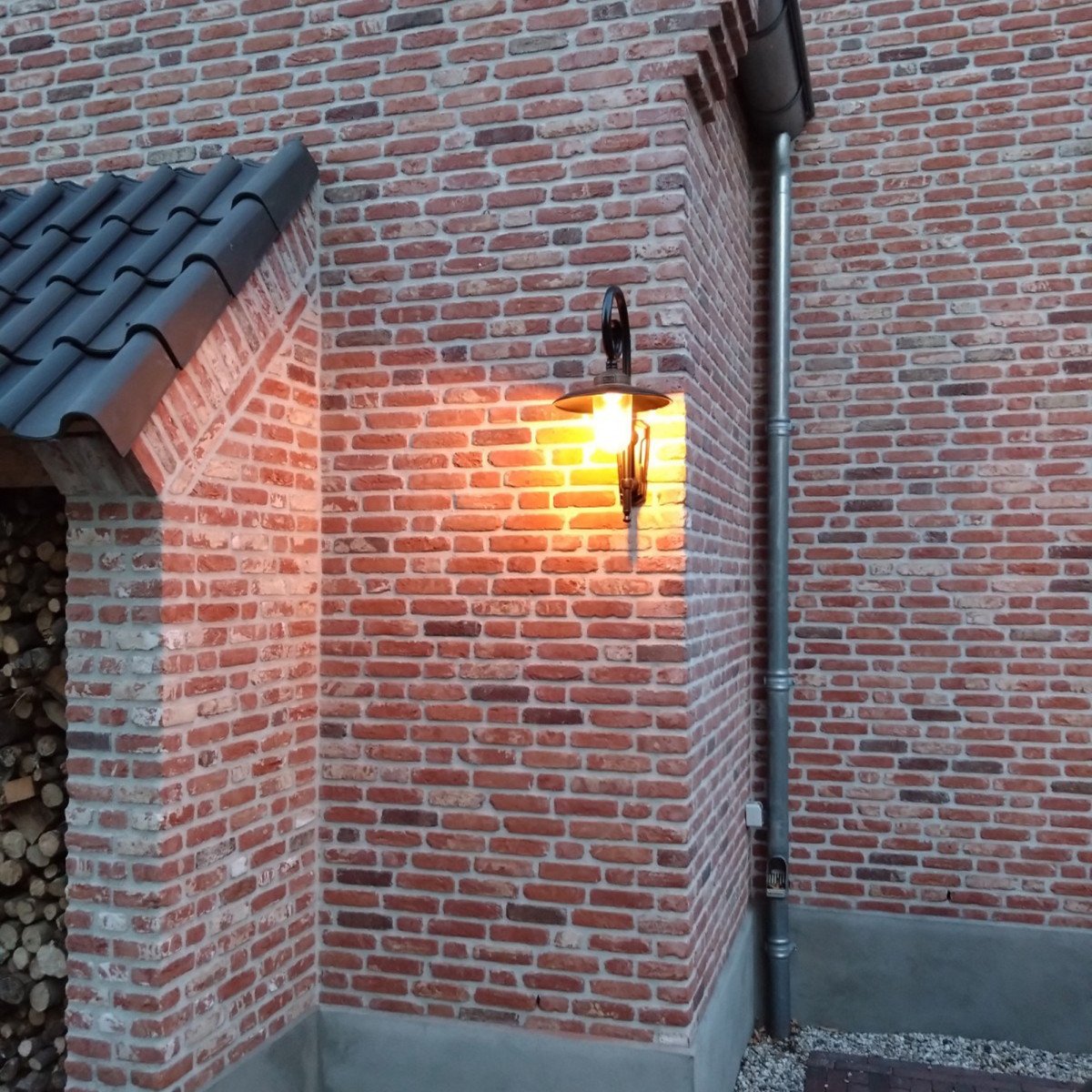 Buitenlamp Orly met sierlijke krularm, zwarte aluminium kap, bronzen flens en glazen stolp,  Wandlamp in Franse stijl.