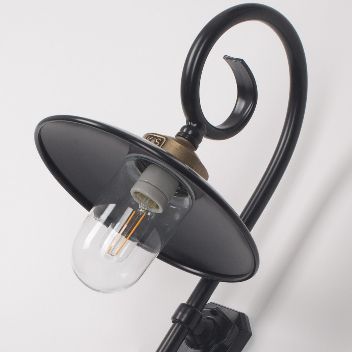 Buitenlamp Orly met sierlijke krularm, zwarte aluminium kap, bronzen flens en glazen stolp,  Wandlamp in Franse stijl.