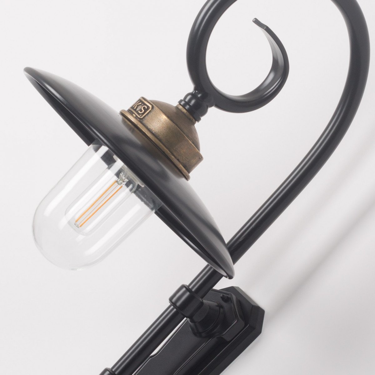 Buitenlamp Orly met sierlijke krularm, zwarte aluminium kap, bronzen flens en glazen stolp,  Wandlamp in Franse stijl.