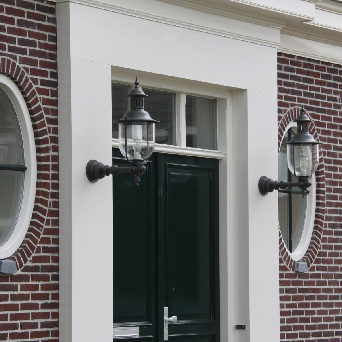 Klassieke bronzen wandlamp met ronde glazen stolp